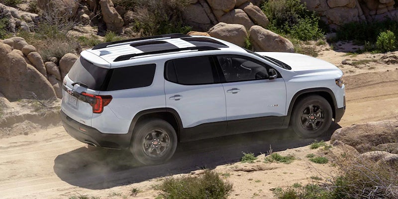 White GMC Acadia running on rough Road