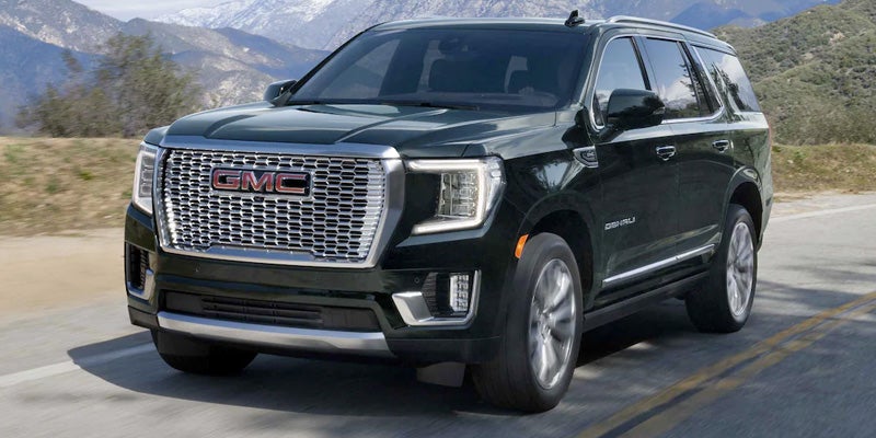GMC Yukon Running on road between hills
