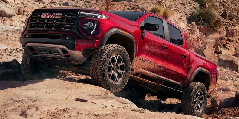 2026 GMC Canyon AT4X driving on rugged off-road terrain
